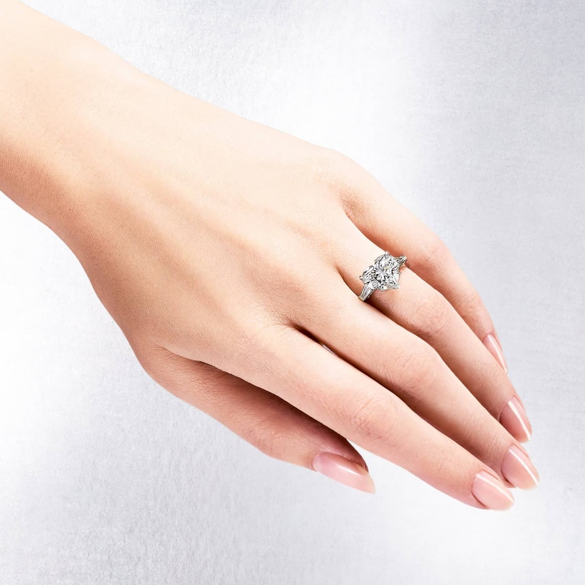 Hand wearing a round brilliant cut diamond ring