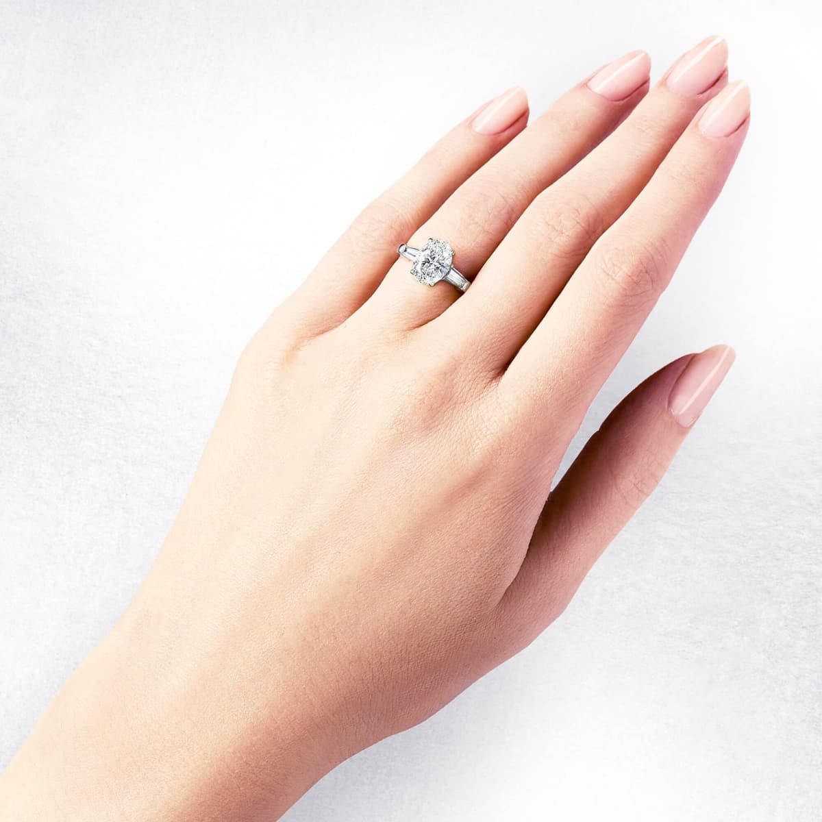 Hand wearing a round brilliant cut diamond ring